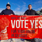 People Before Profit's Councillor Shaun Harkin holding Unite's Seagate Vote Yes for your Union banner in the snow with workers