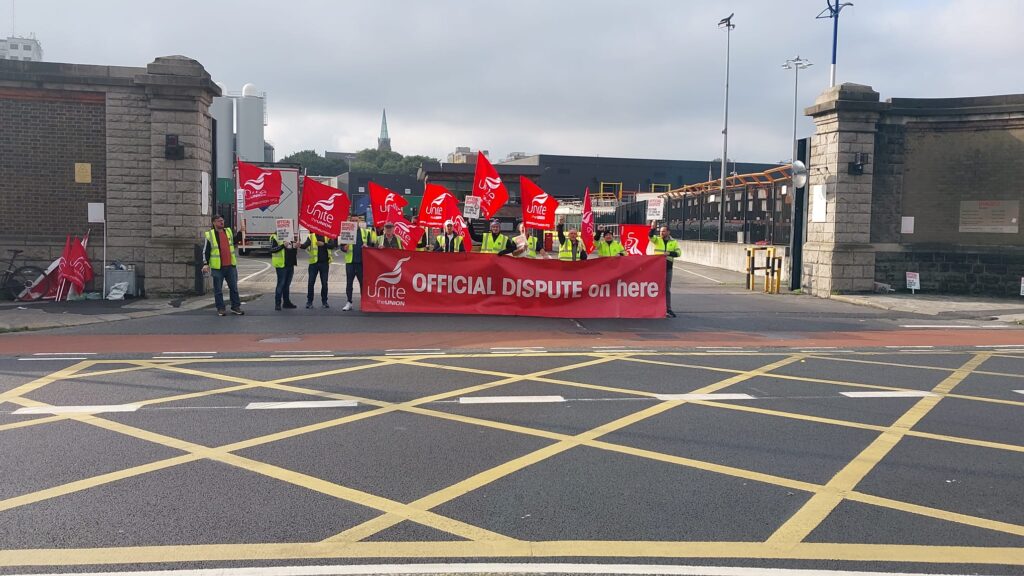 Unite picketers unfurl the 'Official Dispute on here' banner at Diageo who use Jones Engineering to maintain their pipes and electrics and welding. Jones is affiliated to the Mechanical Engineering and Building Servicers Contractors Association, MEBSCA. MEBSCA refuses to reenter talks on Travel Time which was 'temporarily' removed according to workers in 2008. 20 September 2024.
 